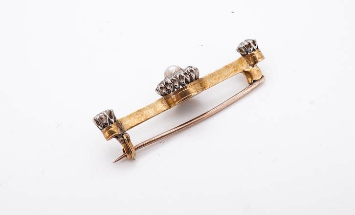 An early to mid 20th century yellow metal, split pearl and diamond cluster set bar brooch, 37mm, gross weight 4.3 grams. Condition - fair